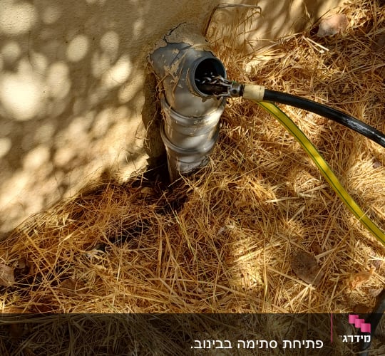 פתיחת סתימה בצנרת ביוב בגינה באמצעות צינור שטיפה בלחץ מים